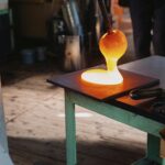 Hot glass being shaped in a workshop in Nagano, Japan. Close-up view of traditional glassblowing process.