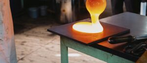 Hot glass being shaped in a workshop in Nagano, Japan. Close-up view of traditional glassblowing process.